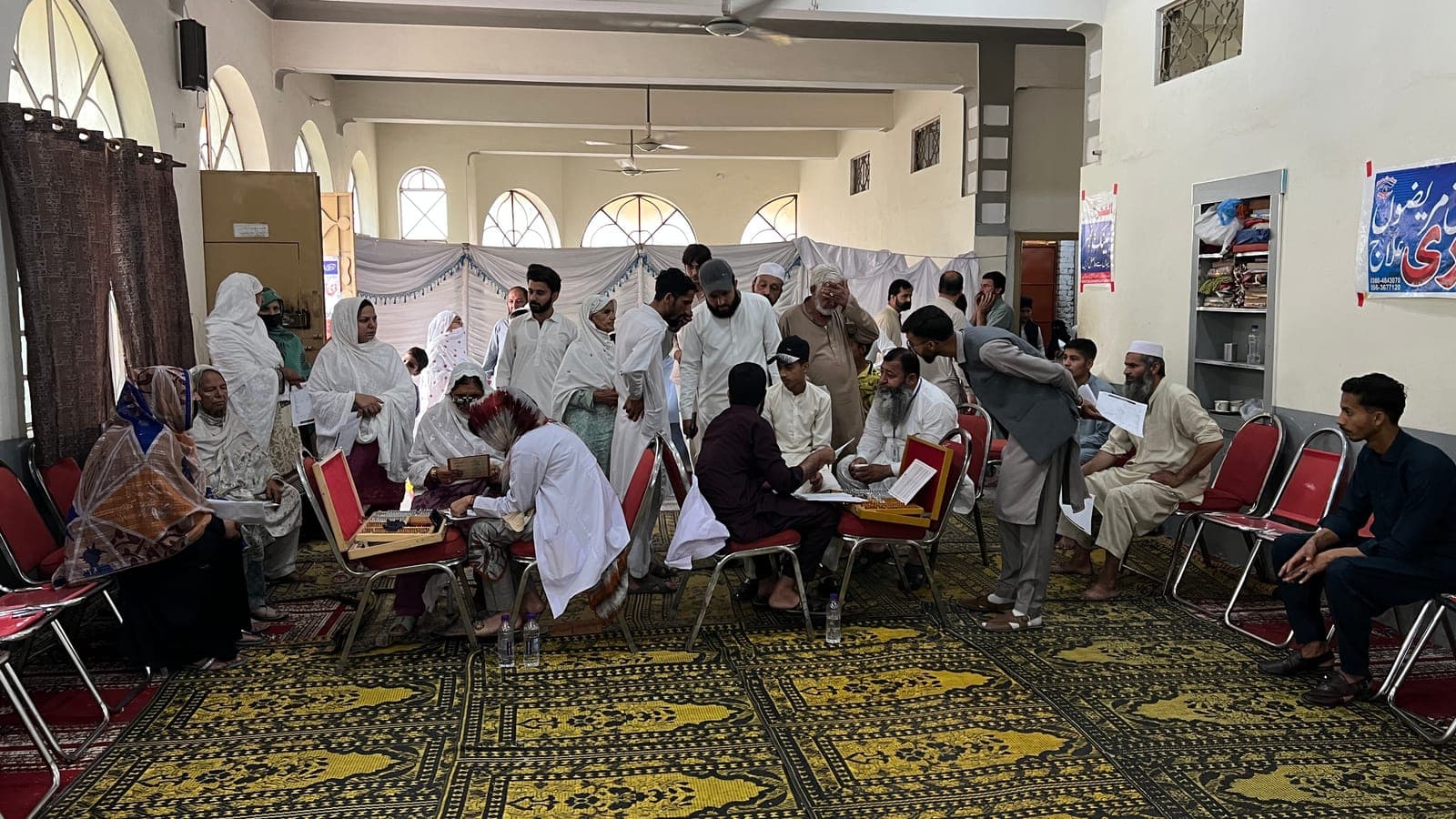 Doctors examining patients in a packed hall at the June 2025 free eye camp